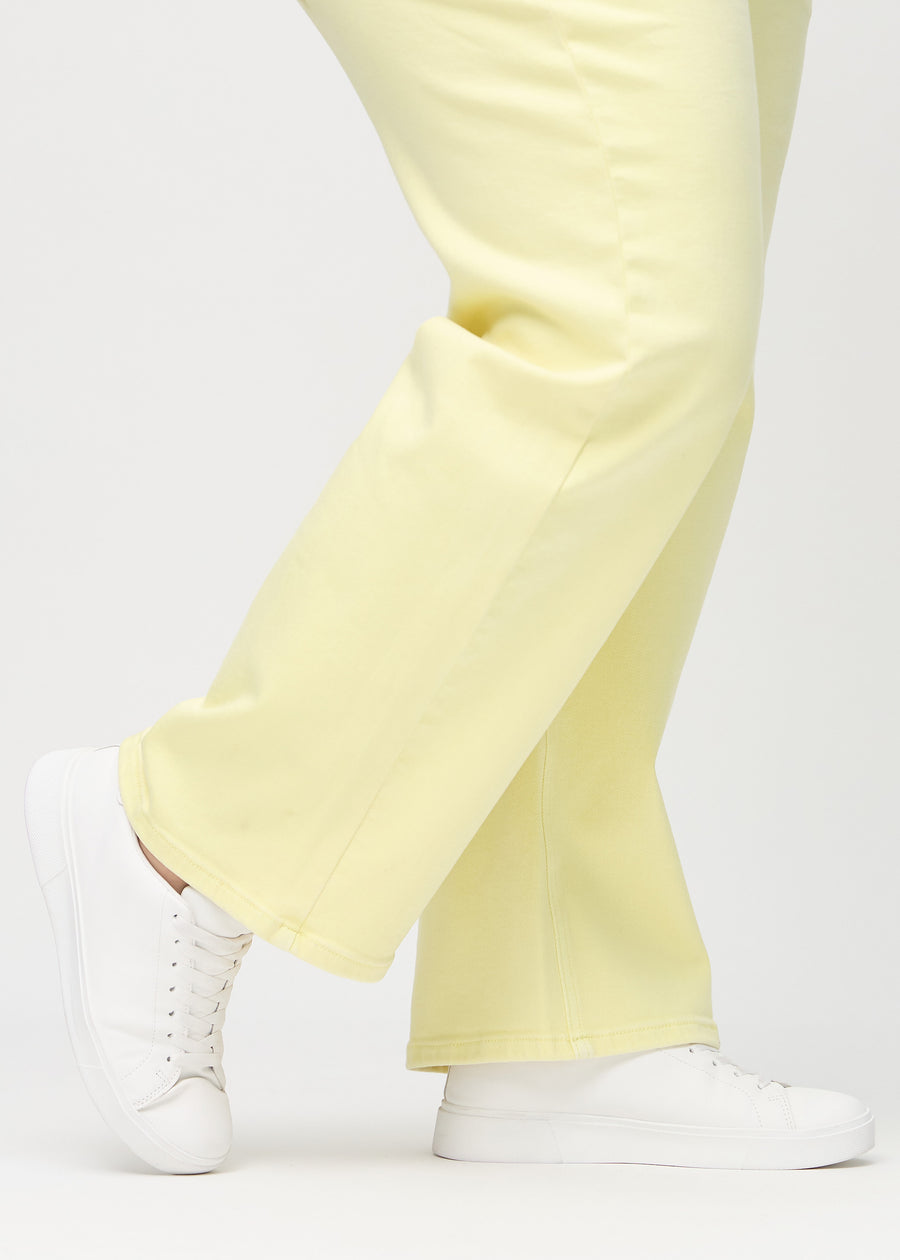 Loose jeans för kvinnor i ljusgul, färgen Lemonades. Närbild vid anklarna på en plus size-modell, som visar de vida bensluten.