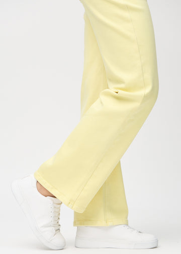 Loose jeans för kvinnor i ljusgul, färgen Lemonades. Närbild vid anklarna på en modell, som visar de vida bensluten.