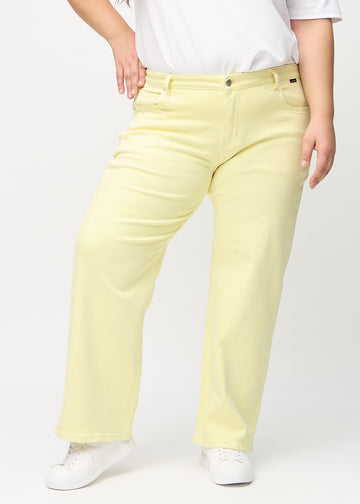 Loose jeans för kvinnor i ljusgul, färgen Lemonades. Framifrån på en plus size-modell, med rymlig passform och vida ben.