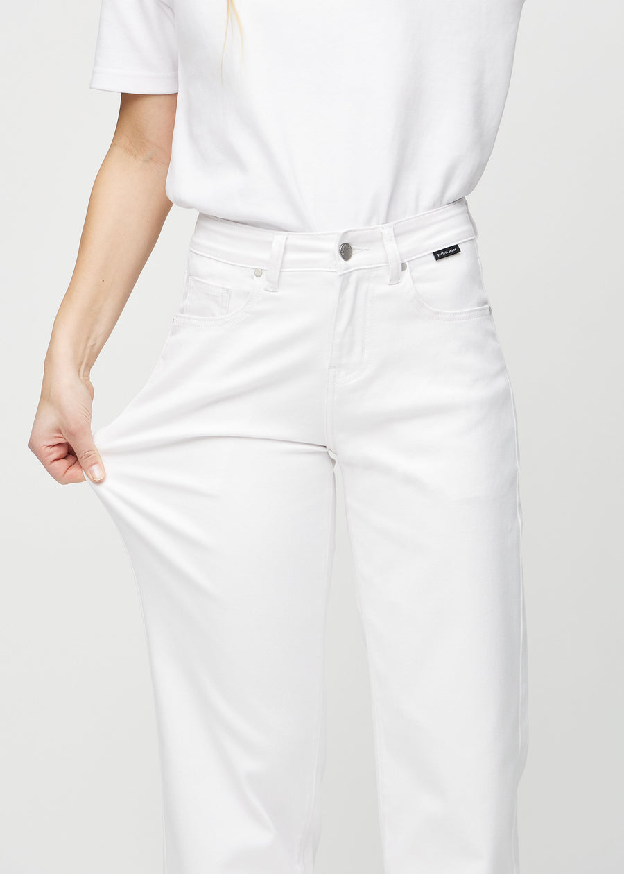 Loose jeans för kvinnor i vit, färgen Marguerites. En modell drar i jeanstyget vid låret för att visa stretchen.
