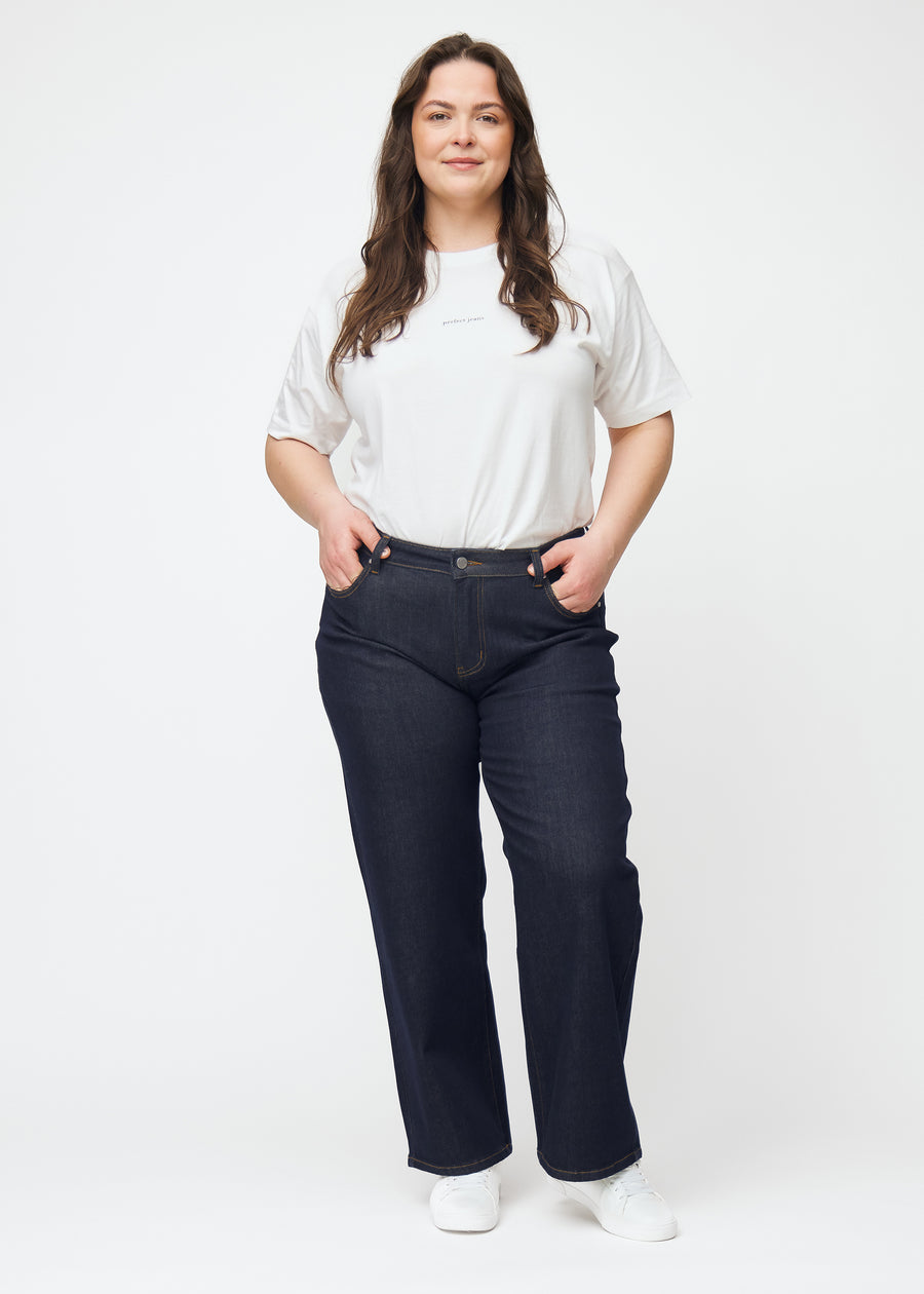 Helbild av plus-size-modell i djupt mörkblå denim jeans för kvinnor i färgen Midnights med loose passform.