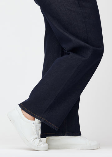 Djupt mörkblå denim jeans för kvinnor i färgen Midnights med loose passform sedd i närbild vid anklarna på plus-size-modell för att visa den breda avslutningen.