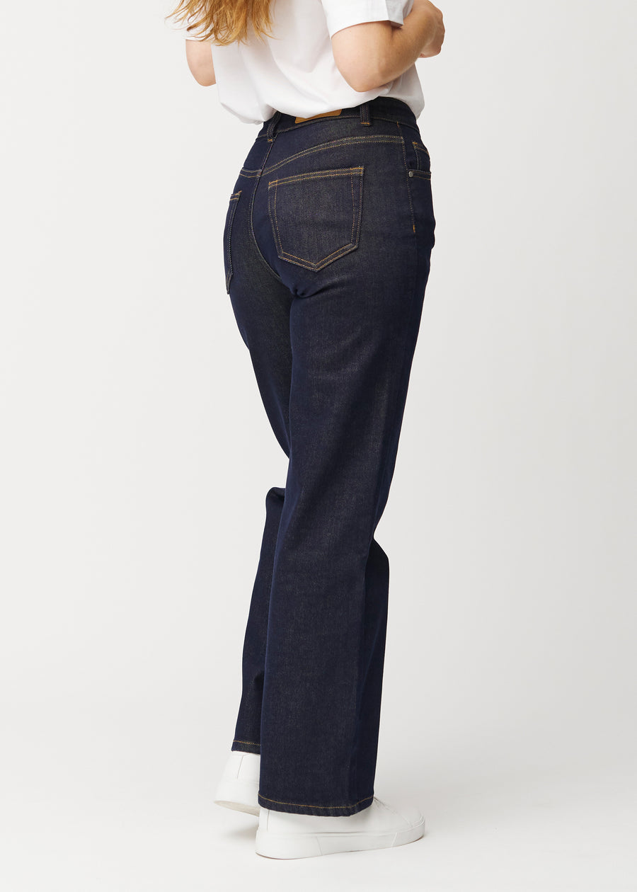 Djup mörkblå denim jeans för kvinnor i färgen Midnights sedd bakifrån, så att den lösa passformen kan ses.