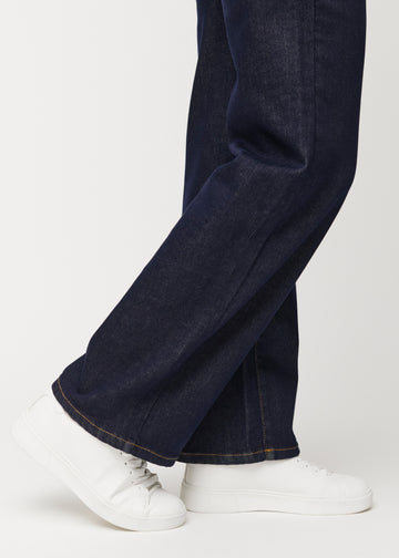 Djup mörkblå denim jeans för kvinnor i färgen Midnights med loose passform sedd i närbild vid anklarna för att visa det breda avslutet.