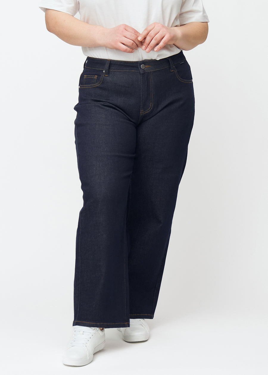 Djupt mörkblå denim jeans för kvinnor i färgen Midnights med loose passform sedd framifrån på plus-size-modell.