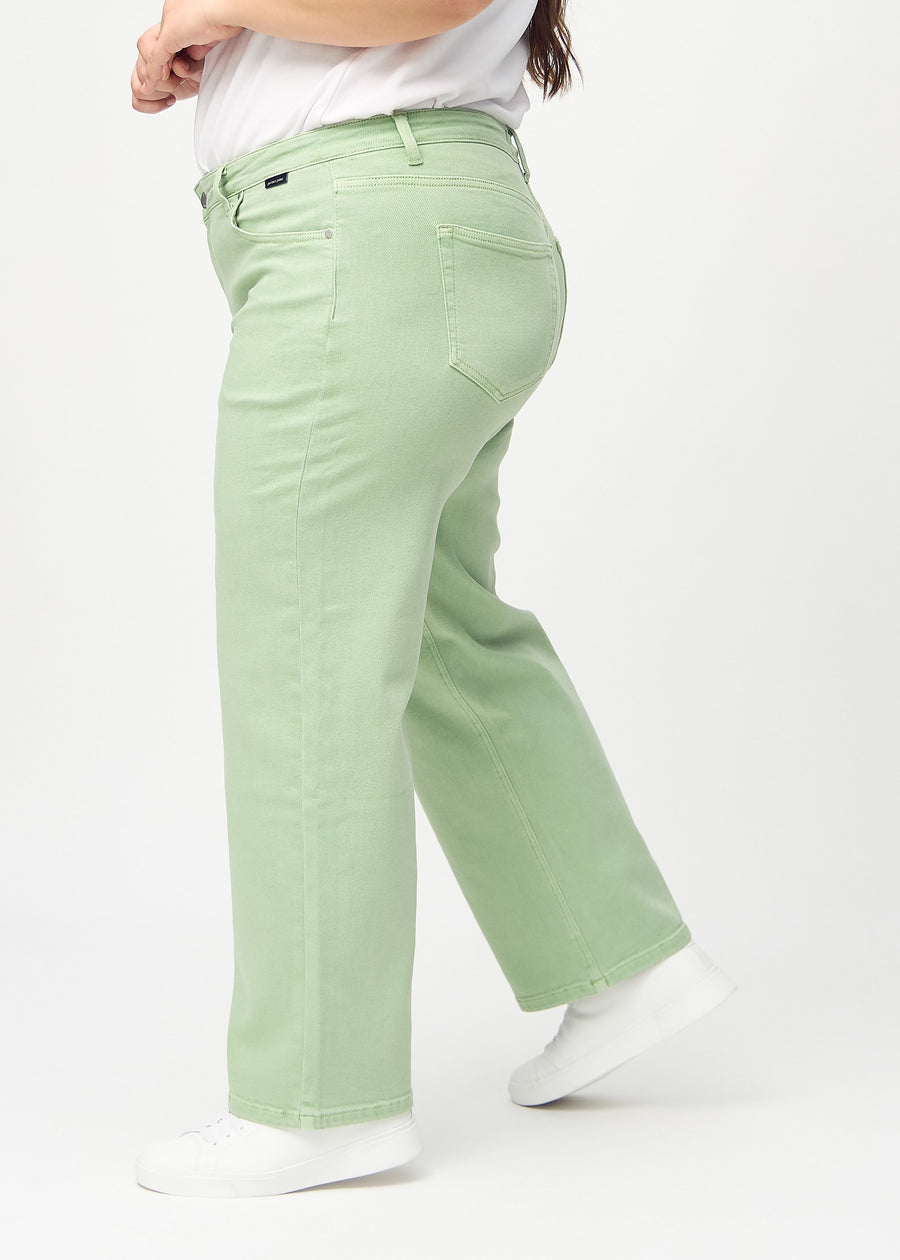 Loose jeans för kvinnor i ljusgrön, färgen Mints. Från sidan på en plus size-modell, med synlig lös passform.