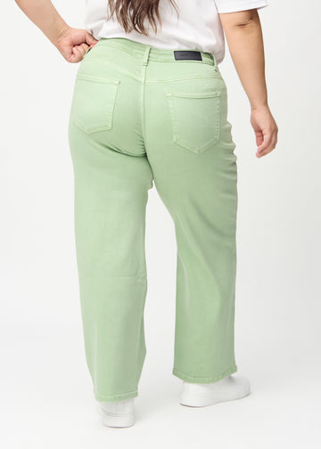 Loose jeans för kvinnor i ljusgrön, färgen Mints. Bakifrån på en plus size-modell, så att hela den lösa passformen syns.