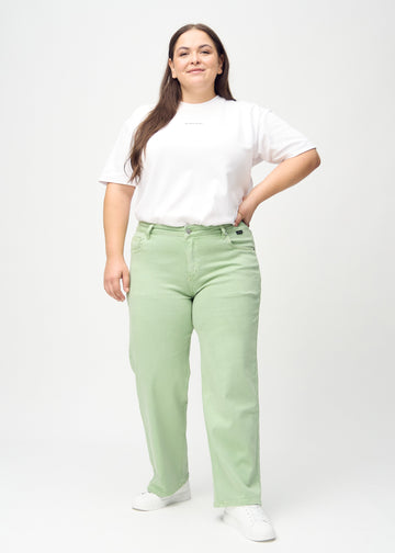 Loose jeans för kvinnor i ljusgrön, färgen Mints. Helbild av en plus size-modell som bär löst sittande jeans.