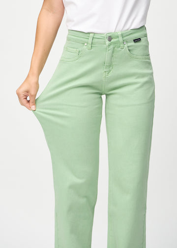 Loose jeans för kvinnor i ljusgrön, färgen Mints. En modell drar i jeanstyget vid låret för att visa stretchen.