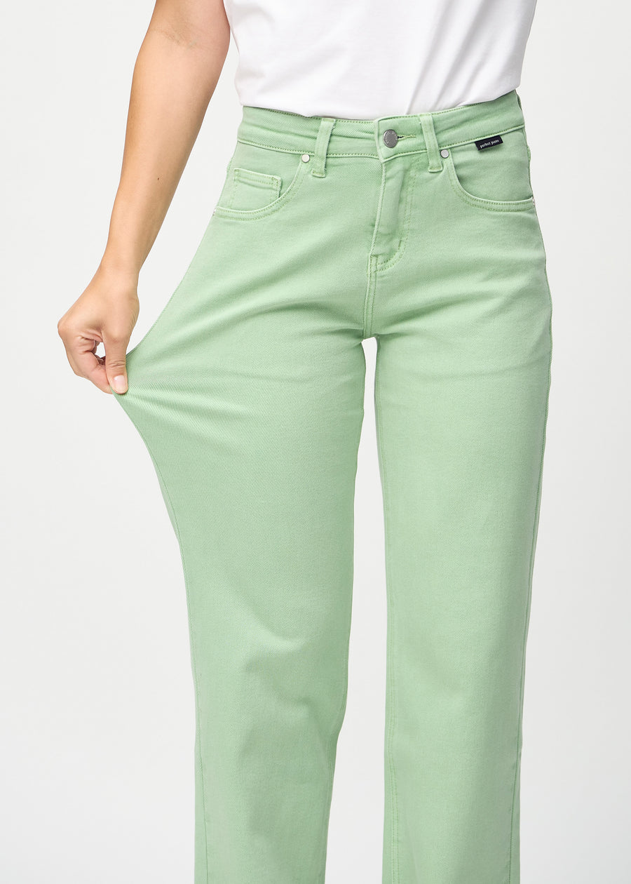 Loose jeans för kvinnor i ljusgrön, färgen Mints. En modell drar i jeanstyget vid låret för att visa stretchen.