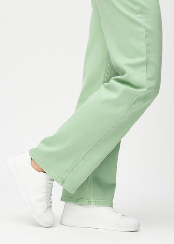 Loose jeans för kvinnor i ljusgrön, färgen Mints. Närbild vid anklarna på en modell, som visar de vida bensluten.