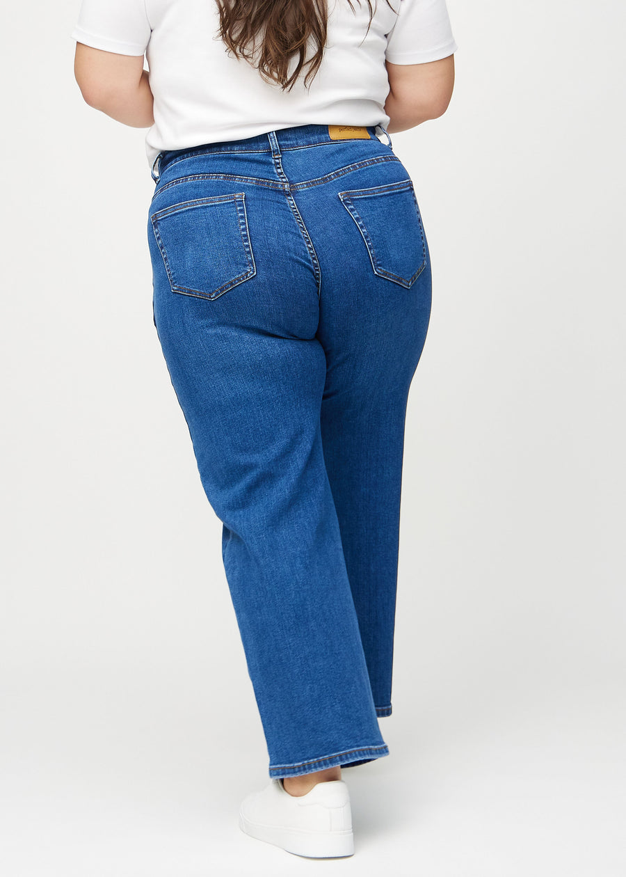 Loose jeans för kvinnor i mörkblå, färgen Oceans. Bakifrån på en plus size-modell, så att hela den lösa passformen syns.