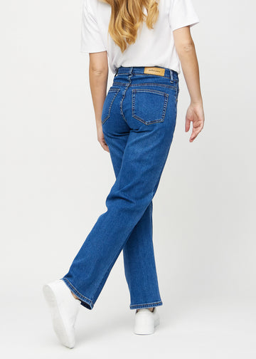 Loose jeans för kvinnor i mörkblå, färgen Oceans. Bakifrån på en modell, så att hela den lösa passformen syns.