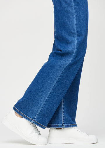 Loose jeans för kvinnor i mörkblå, färgen Oceans. Närbild vid anklarna på en modell, som visar de vida bensluten.