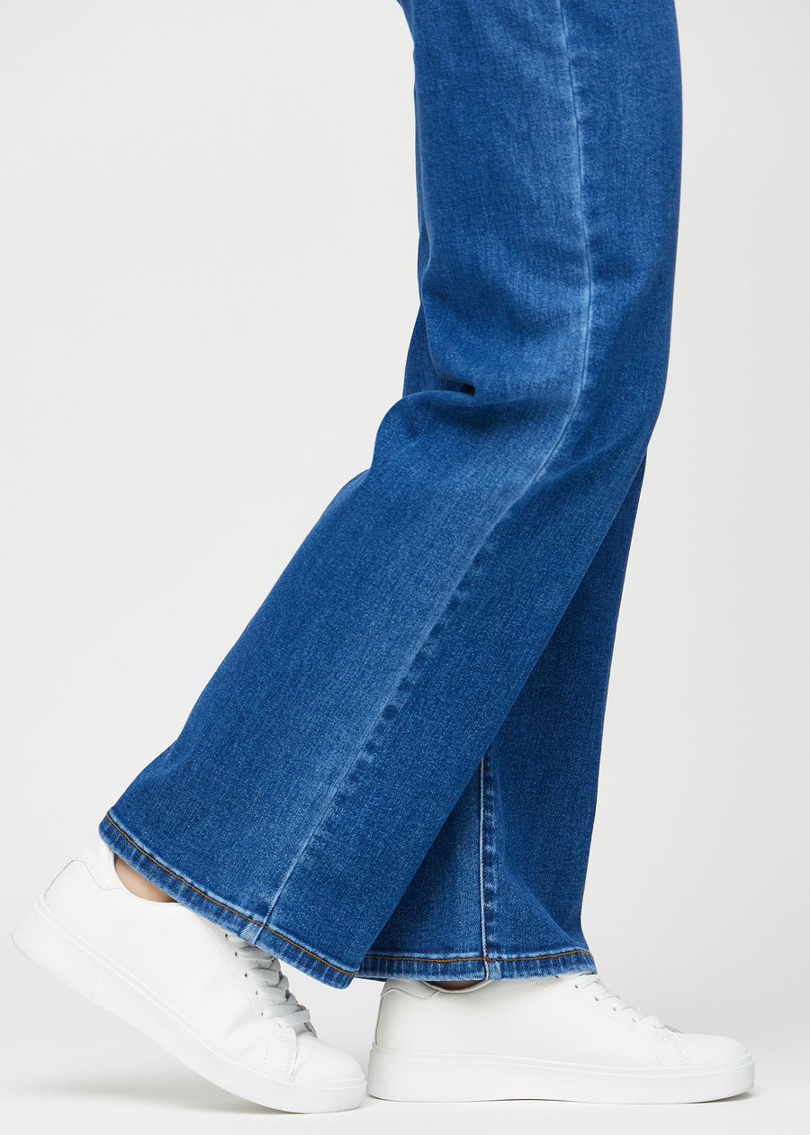 Loose jeans för kvinnor i mörkblå, färgen Oceans. Närbild vid anklarna på en modell, som visar de vida bensluten.