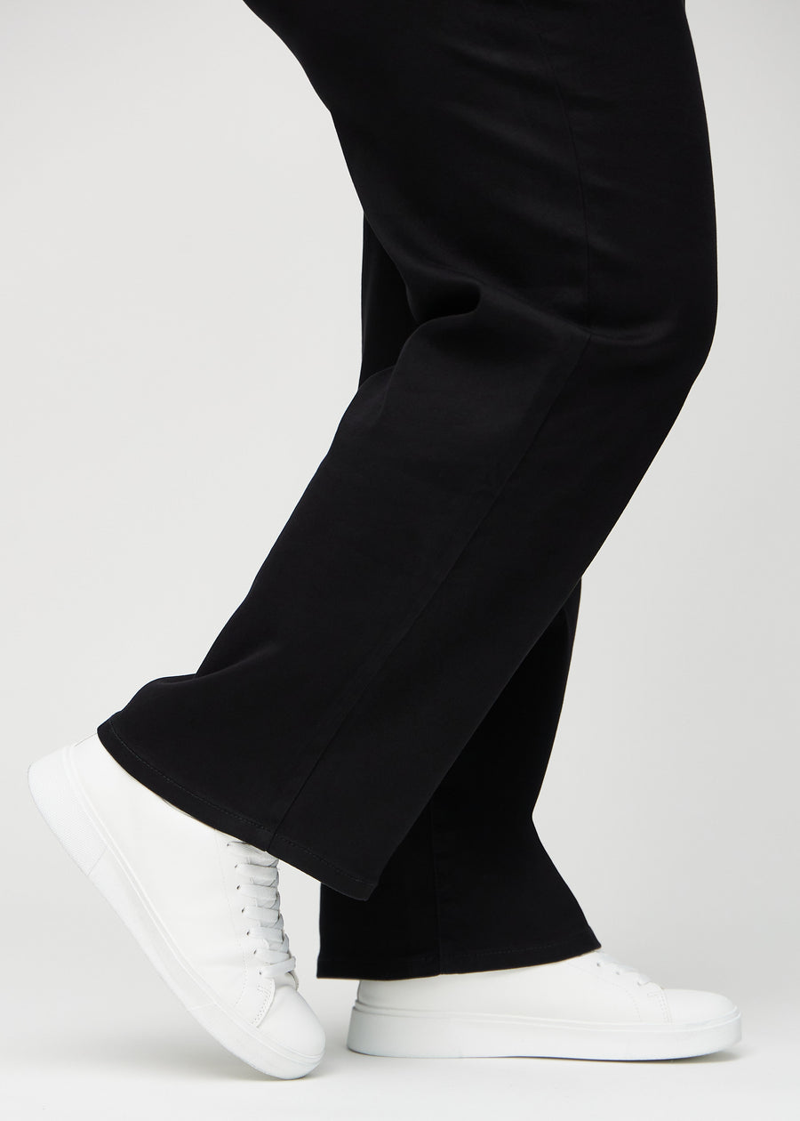 En plus-size-modells anklar, så att man kan se hur löst jeansen sitter i en Loose passform.