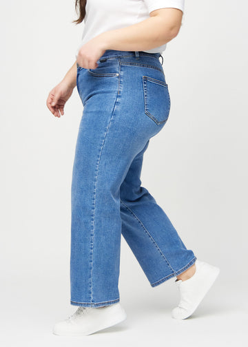 Loose jeans för kvinnor i blå, färgen Rivers. Från sidan på en plus size-modell, med synlig lös passform.