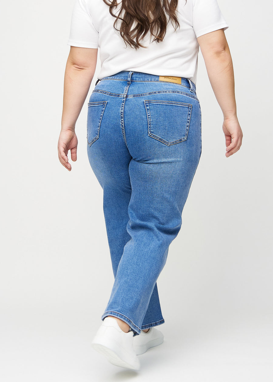 Loose jeans för kvinnor i blå, färgen Rivers. Bakifrån på en plus size-modell, så att hela den lösa passformen syns.