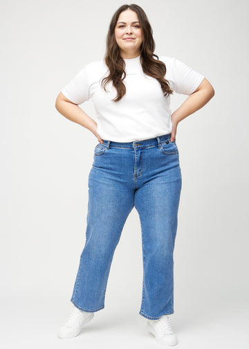 Loose jeans för kvinnor i blå, färgen Rivers. Helbild av en plus size-modell som bär löst sittande jeans.