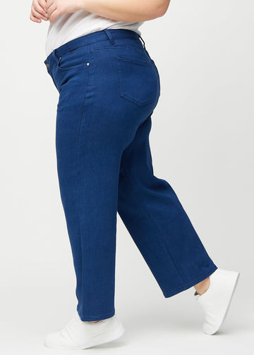 Loose jeans för kvinnor i mörkblå, färgen Royals. Från sidan på en plus size-modell, med synlig lös passform.