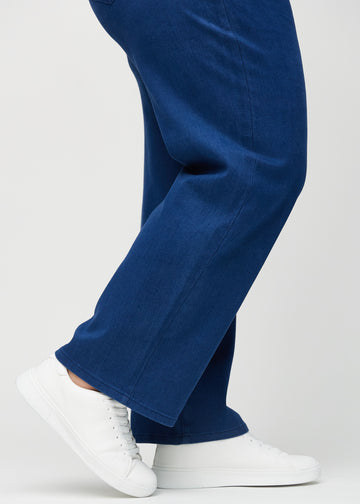 Loose jeans för kvinnor i mörkblå, färgen Royals. Närbild vid anklarna på en plus size-modell, som visar de vida bensluten.