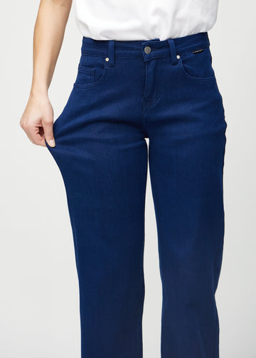 Loose jeans för kvinnor i mörkblå, färgen Royals. En modell drar i jeanstyget vid låret för att visa stretchen.
