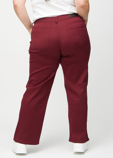 Loose jeans för kvinnor i mörkröd, färgen Santas. Bakifrån på en plus size-modell, så att hela den lösa passformen syns.
