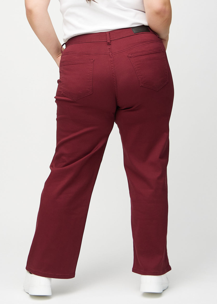 Loose jeans för kvinnor i mörkröd, färgen Santas. Bakifrån på en plus size-modell, så att hela den lösa passformen syns.