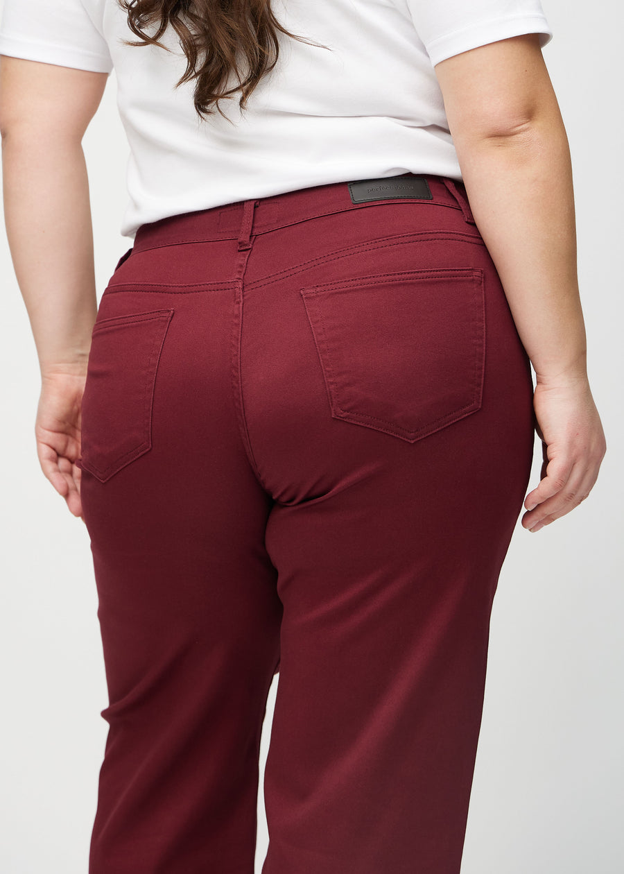 Loose jeans för kvinnor i mörkröd, färgen Santas. Närbild bakifrån på en plus size-modell, som visar passform och detaljer.