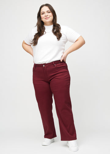 Loose jeans för kvinnor i mörkröd, färgen Santas. Helbild av en plus size-modell som bär löst sittande jeans.