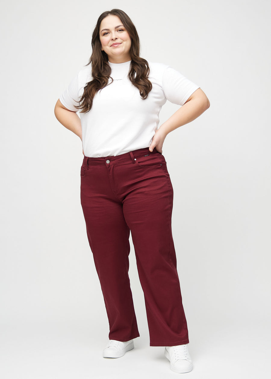 Loose jeans för kvinnor i mörkröd, färgen Santas. Helbild av en plus size-modell som bär löst sittande jeans.