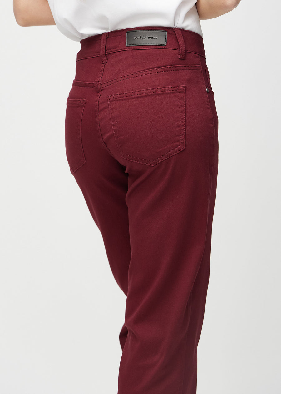 Loose jeans för kvinnor i mörkröd, färgen Santas. Närbild bakifrån på en modell, som visar passform och detaljer.