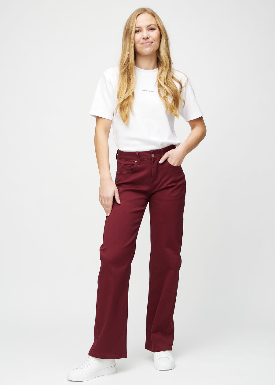 Loose jeans för kvinnor i mörkröd, färgen Santas. Helbild av en modell som bär löst sittande jeans.