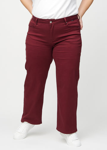 Loose jeans för kvinnor i mörkröd, färgen Santas. Framifrån på en plus size-modell, med rymlig passform och vida ben.
