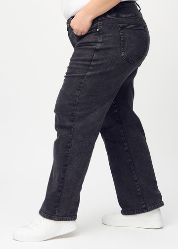 Mörkgrå denim loose jeans sedd från sidan på en plus-size-modell.