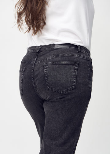 Mörkgrå denim loose jeans sedd bakifrån i närbild på en plus-size-modell för att visa detaljer.