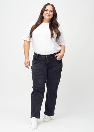 Helbild av en plus-size-modell i mörkgrå denim loose jeans.