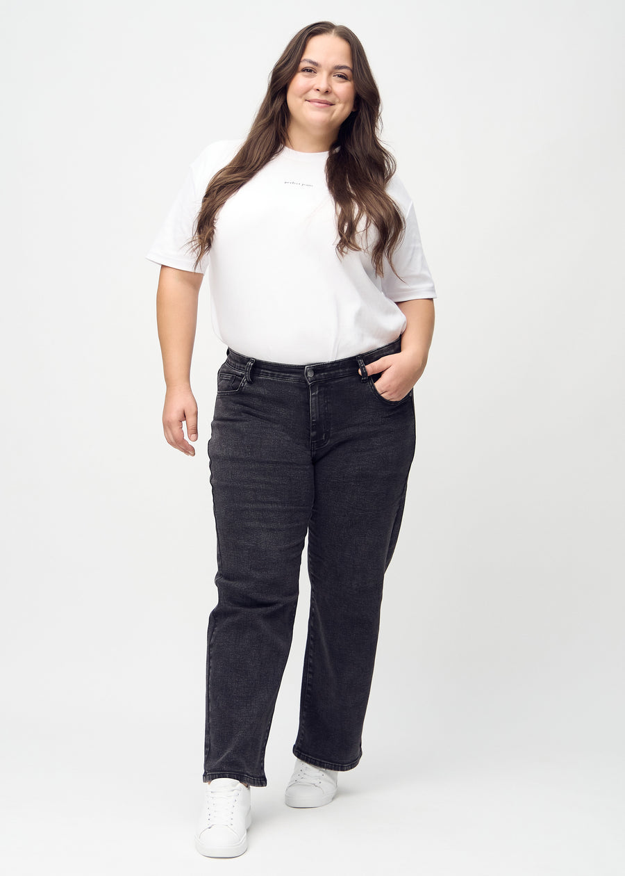 Helbild av en plus-size-modell i mörkgrå denim loose jeans.