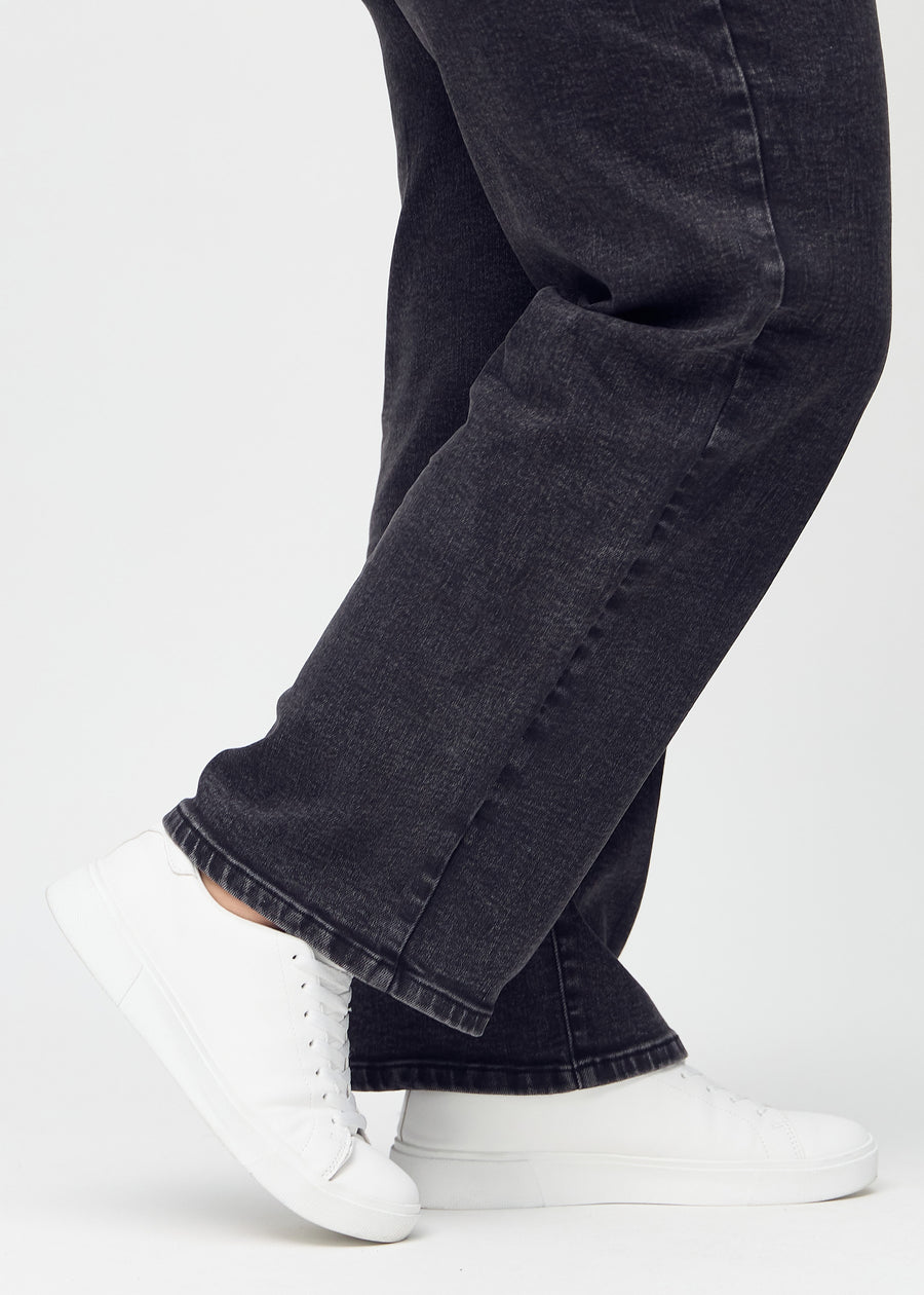 Anklarna på en plus-size-modell, så att man kan se hur löst jeansen sitter.