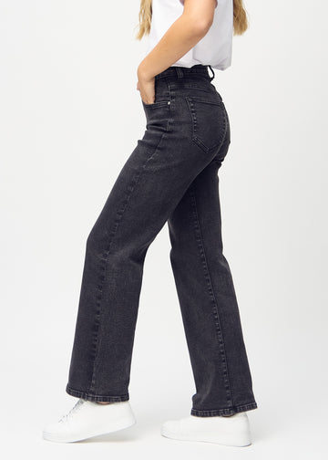 Mörkgrå denim loose jeans sedd från sidan på modell.