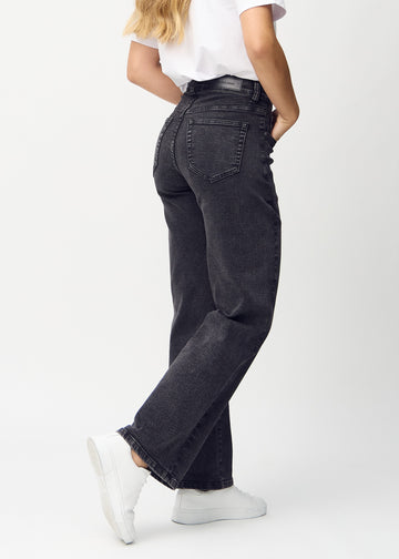 Mörkgrå denim loose jeans sedd bakifrån, så att man kan se hela produkten.
