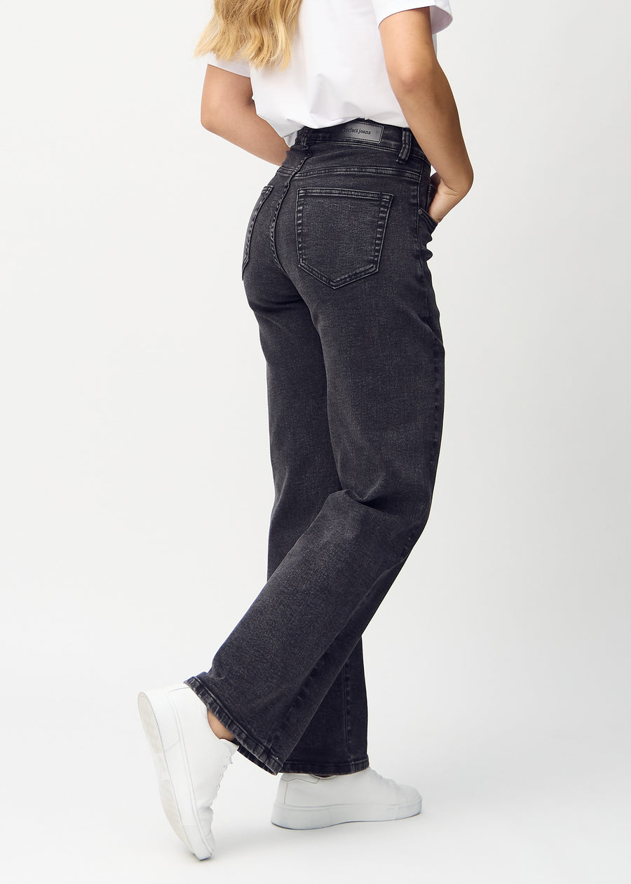 Mörkgrå denim loose jeans sedd bakifrån, så att man kan se hela produkten.