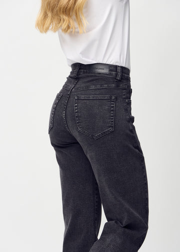 Mörkgrå denim loose jeans sedd bakifrån i närbild för att visa detaljer.