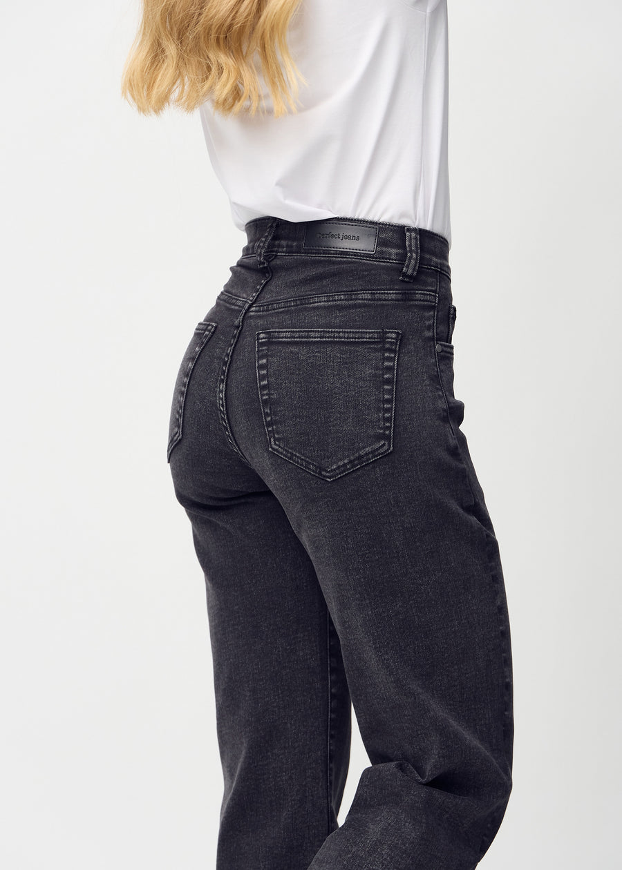 Mörkgrå denim loose jeans sedd bakifrån i närbild för att visa detaljer.