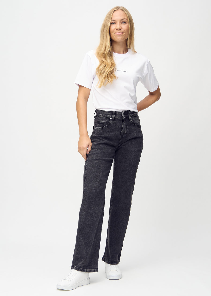 Helbild av modell i mörkgrå denim loose jeans.