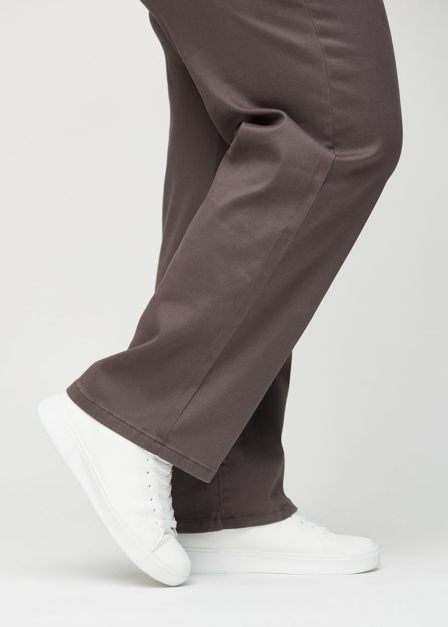 Loose jeans för kvinnor i gråbrun, färgen Thunders. Närbild vid anklarna på en plus size-modell, som visar de vida bensluten.