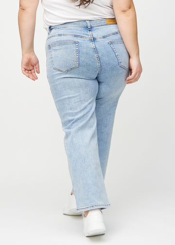 Ljus denim loose jeans sedd bakifrån på en plus-size-modell, så att man kan se hela produkten.