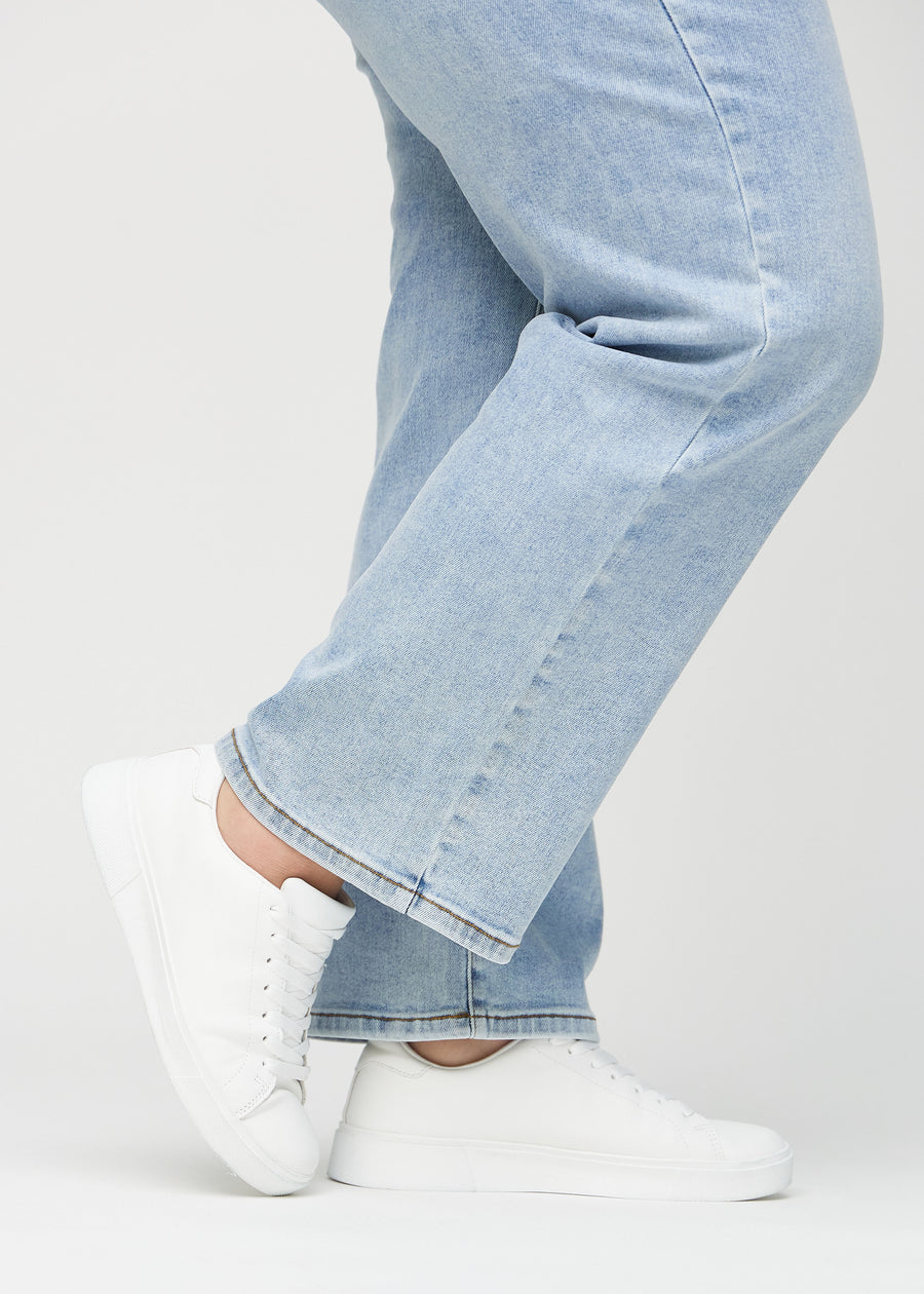 Anklarna på en plus-size-modell, så att man kan se hur löst jeansen sitter.