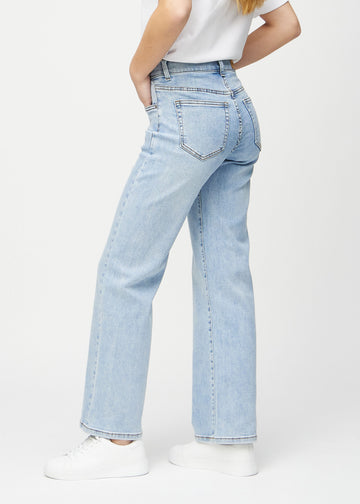 Ljus denim loose jeans sedd från sidan på modell.