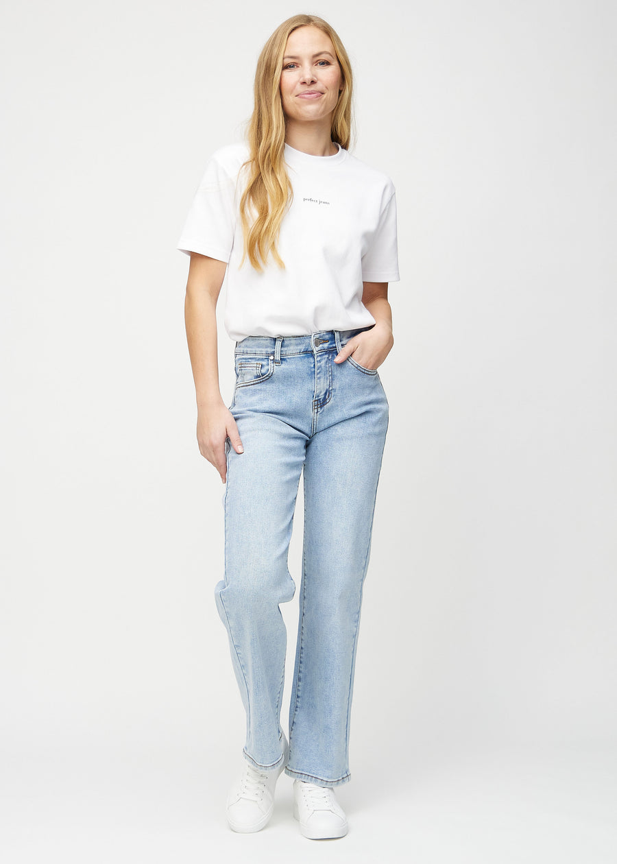 Helbild av modell i ljus denim loose jeans.